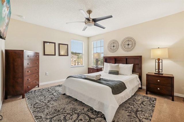 carpeted bedroom featuring ceiling fan and a textured ceiling