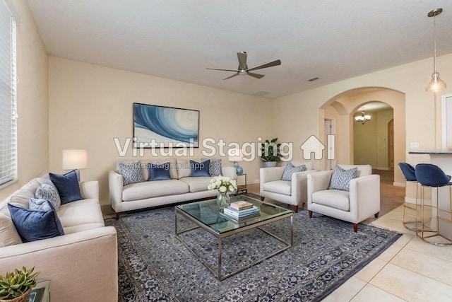 living room featuring light tile patterned flooring, a textured ceiling, and ceiling fan