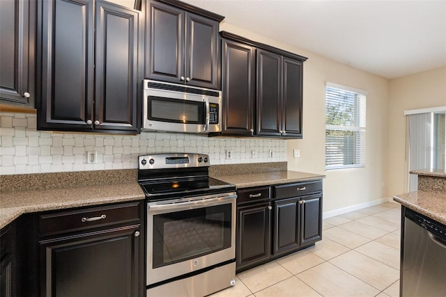 kitchen with appliances with stainless steel finishes, light tile patterned floors, and backsplash