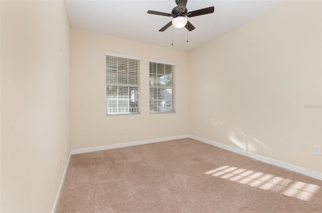 carpeted spare room with ceiling fan