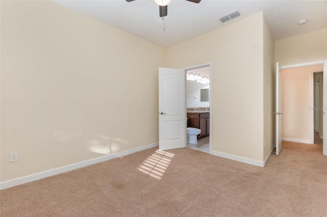 unfurnished bedroom with connected bathroom, light colored carpet, and ceiling fan