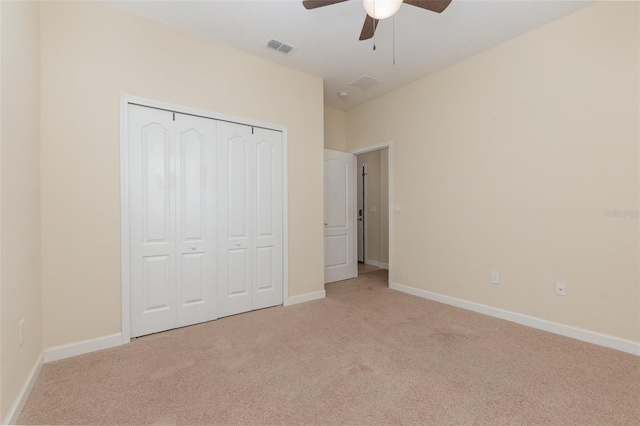 unfurnished bedroom with light carpet, a closet, and ceiling fan