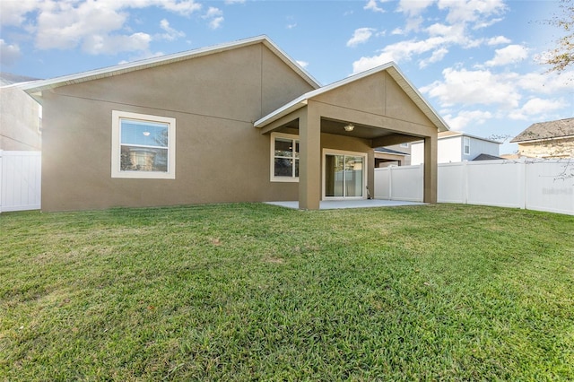 rear view of house with a lawn and a patio