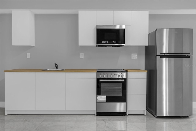 kitchen with sink, white cabinets, and appliances with stainless steel finishes