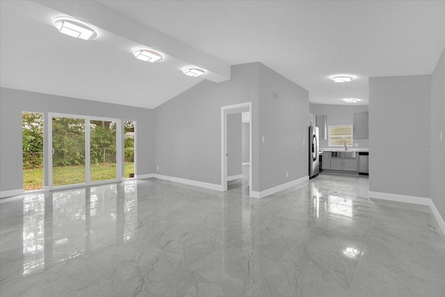 unfurnished living room with vaulted ceiling with beams and sink