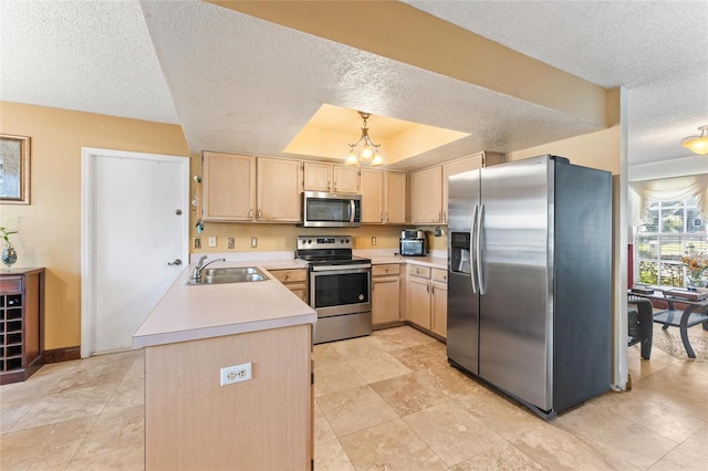 kitchen with light brown cabinetry, sink, a tray ceiling, and appliances with stainless steel finishes