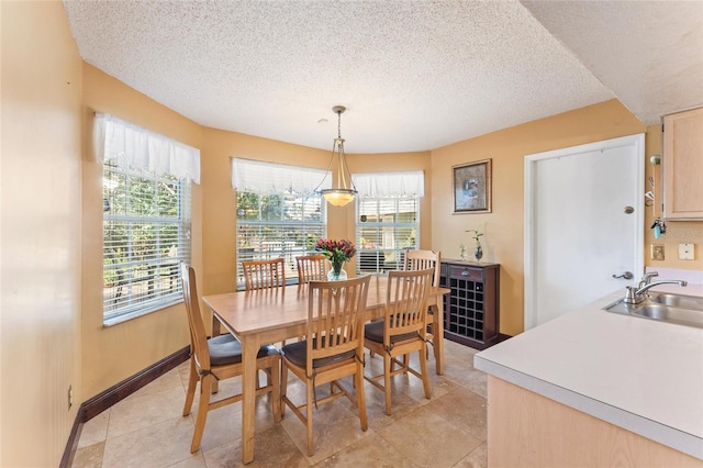 tiled dining space with sink and a textured ceiling