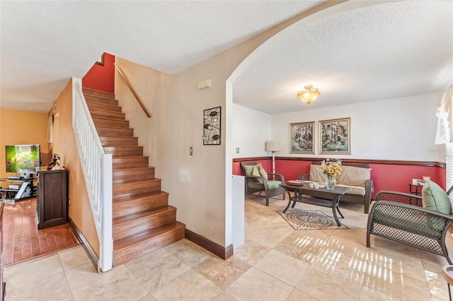 stairway featuring tile patterned flooring and a textured ceiling