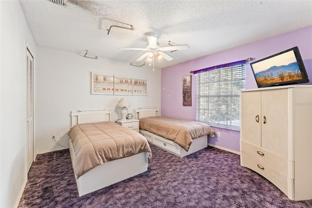 carpeted bedroom with ceiling fan and a textured ceiling