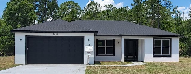 ranch-style house with a garage, a front yard, driveway, and stucco siding