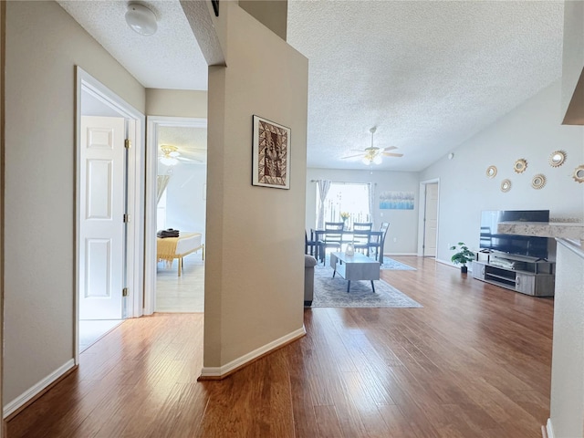 corridor with hardwood / wood-style flooring and a textured ceiling