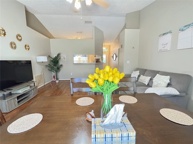 living room with ceiling fan, lofted ceiling, hardwood / wood-style floors, and a textured ceiling