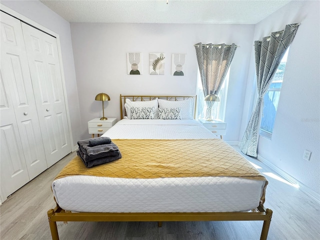 bedroom featuring hardwood / wood-style flooring, a textured ceiling, and a closet