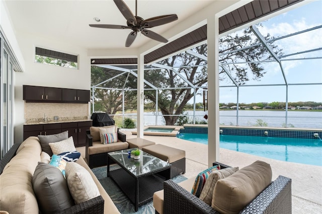 view of swimming pool with a patio area, a water view, an in ground hot tub, a lanai, and outdoor lounge area