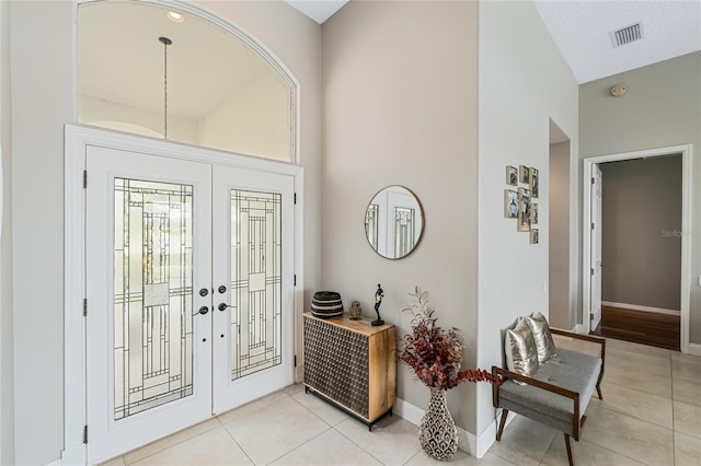 foyer entrance featuring light tile patterned flooring and french doors