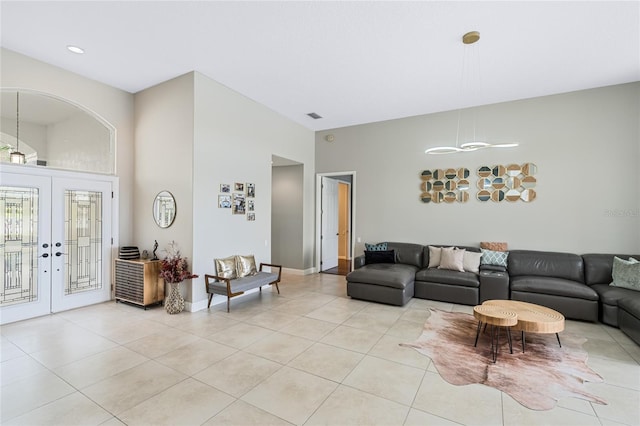 tiled living room with french doors and a towering ceiling