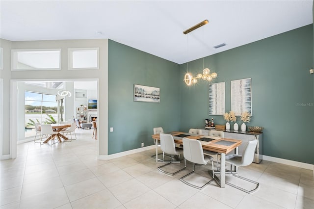 dining area featuring light tile patterned flooring and a notable chandelier