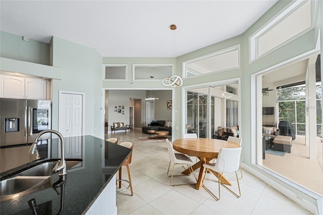 tiled dining room with sink and a high ceiling