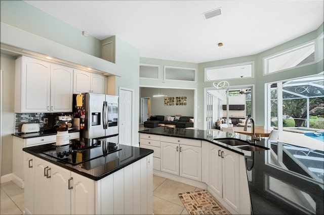 kitchen featuring white cabinets, light tile patterned floors, sink, and stainless steel refrigerator with ice dispenser