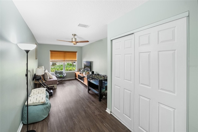 interior space featuring dark hardwood / wood-style flooring, ceiling fan, and a textured ceiling