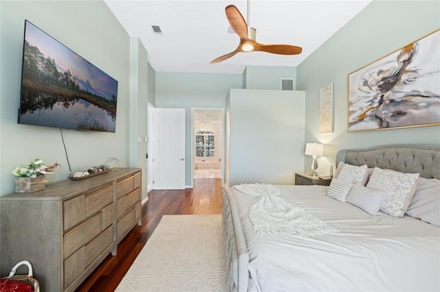 bedroom with ceiling fan, connected bathroom, and dark hardwood / wood-style flooring