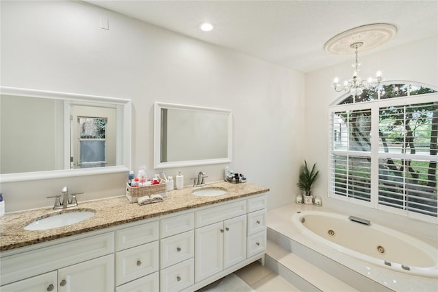 bathroom featuring vanity, a washtub, and an inviting chandelier