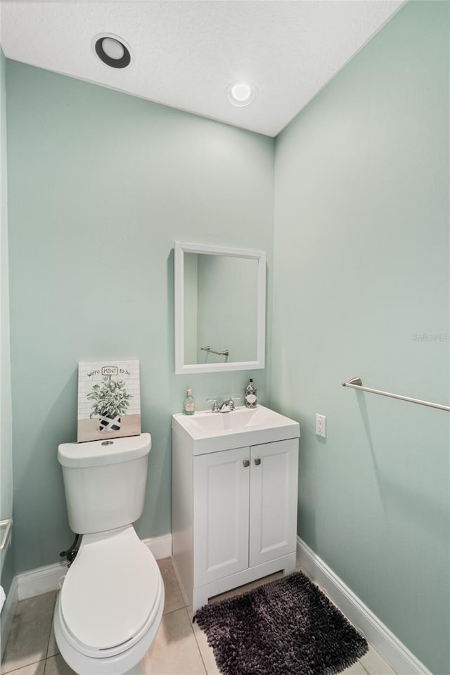 bathroom featuring tile patterned floors, vanity, and toilet