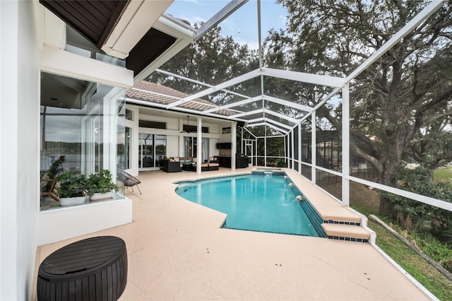 view of swimming pool featuring pool water feature, a patio, and a lanai