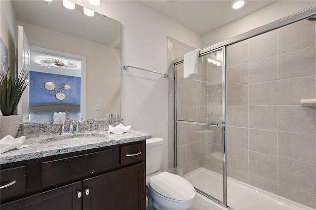 bathroom with an enclosed shower, vanity, and toilet