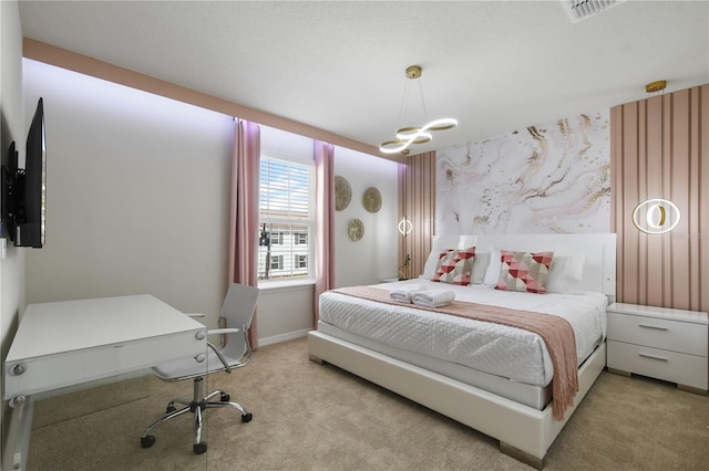 bedroom with an inviting chandelier and light colored carpet