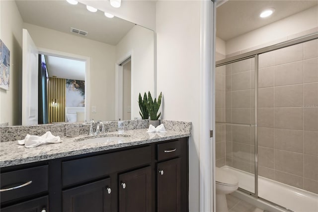 bathroom featuring vanity, walk in shower, tile patterned floors, and toilet