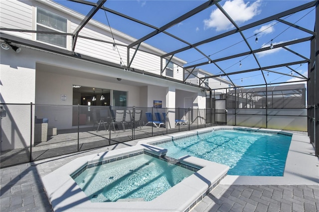 view of pool featuring an in ground hot tub, a patio, and glass enclosure