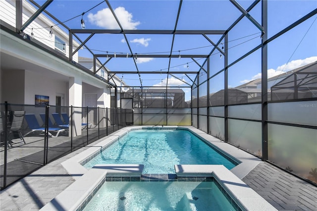 view of swimming pool featuring an in ground hot tub, glass enclosure, and a patio area