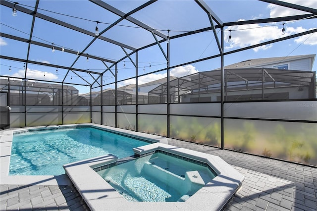 view of swimming pool with an in ground hot tub, a lanai, and a patio