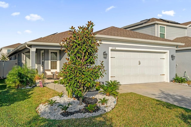 view of front of house with a garage, a front yard, and a porch