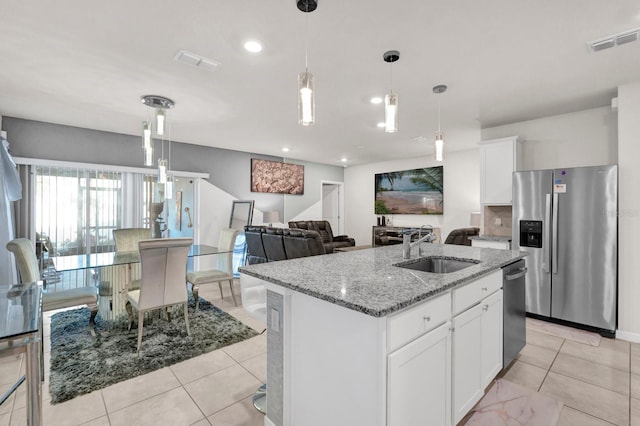 kitchen with pendant lighting, an island with sink, white cabinetry, sink, and stainless steel appliances