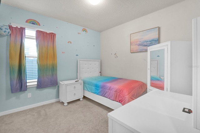 bedroom with light carpet and a textured ceiling