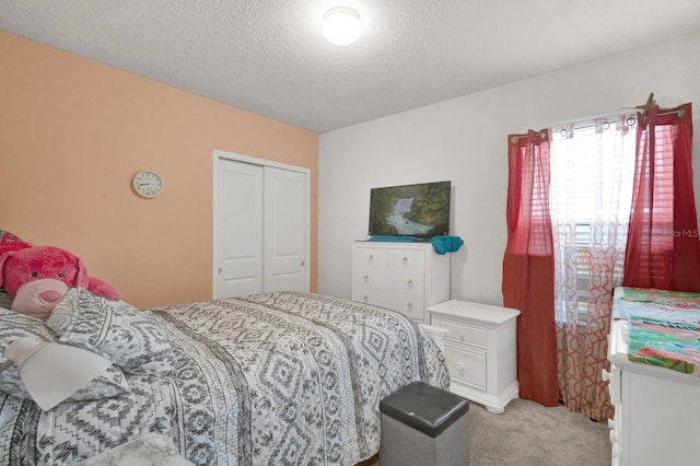 bedroom featuring light colored carpet, a closet, and a textured ceiling