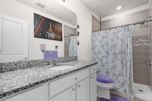 bathroom featuring vanity, toilet, a textured ceiling, and walk in shower