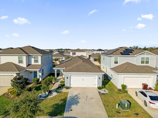 view of front property featuring a garage, a front yard, and solar panels