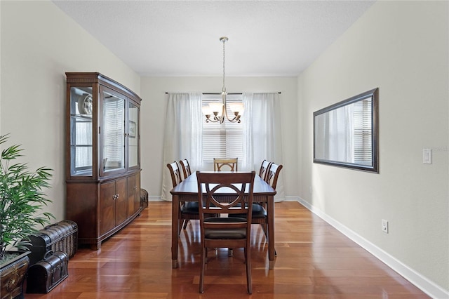 dining space featuring hardwood / wood-style floors and a notable chandelier