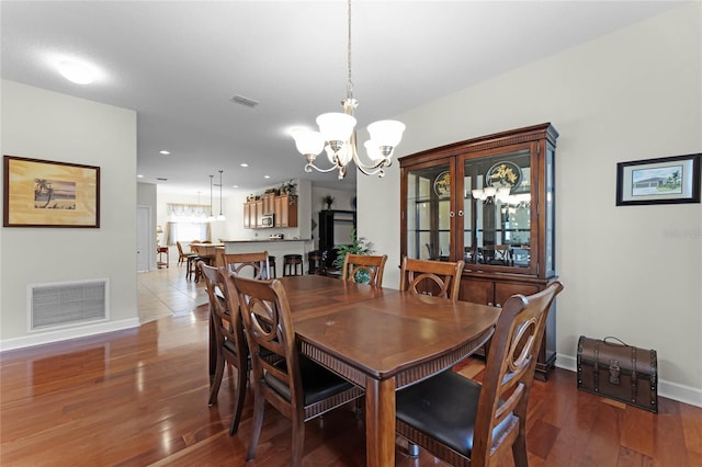 dining space with hardwood / wood-style flooring and a chandelier