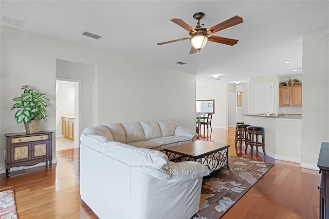 living room with ceiling fan and light hardwood / wood-style floors