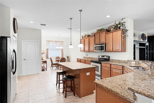 kitchen featuring a kitchen island, pendant lighting, sink, kitchen peninsula, and stainless steel appliances