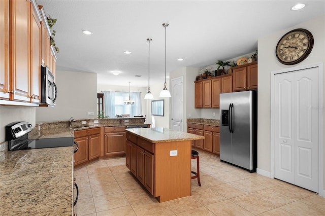 kitchen with appliances with stainless steel finishes, decorative light fixtures, a kitchen breakfast bar, a center island, and kitchen peninsula