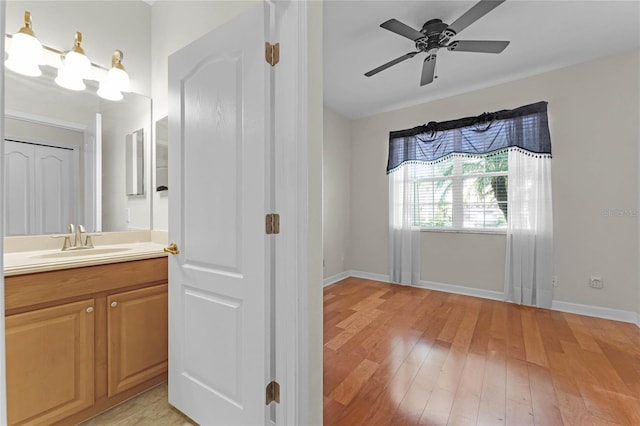 bathroom with hardwood / wood-style flooring, ceiling fan, and vanity