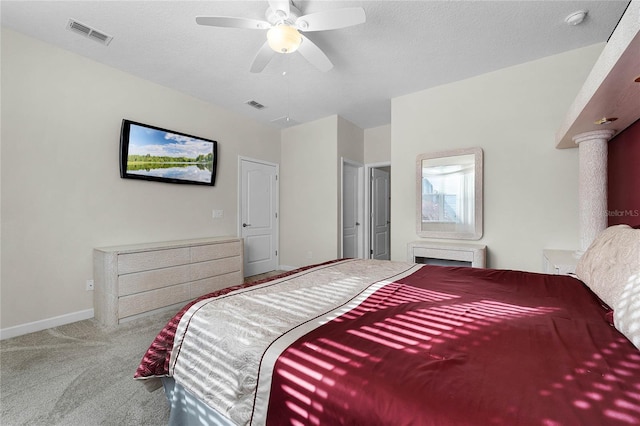 bedroom featuring ceiling fan, light colored carpet, and a textured ceiling