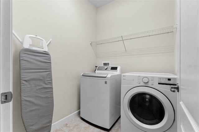 laundry area featuring light tile patterned flooring and washer and clothes dryer