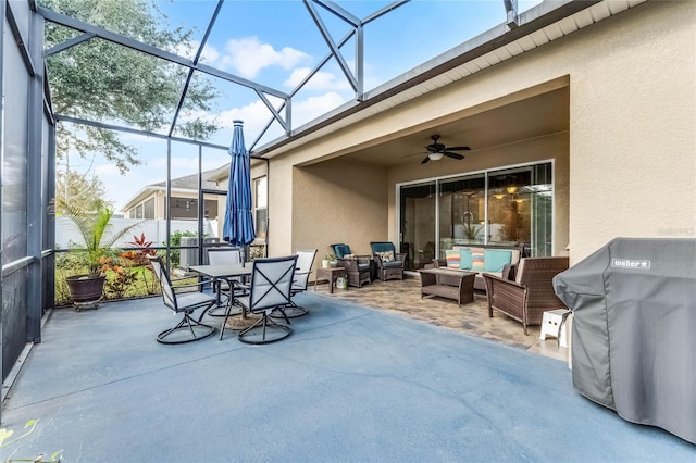 view of patio / terrace featuring ceiling fan, an outdoor living space, and glass enclosure