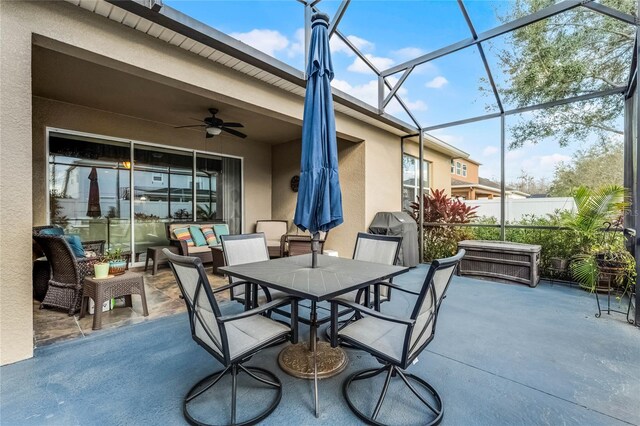 view of patio / terrace featuring area for grilling, ceiling fan, and glass enclosure